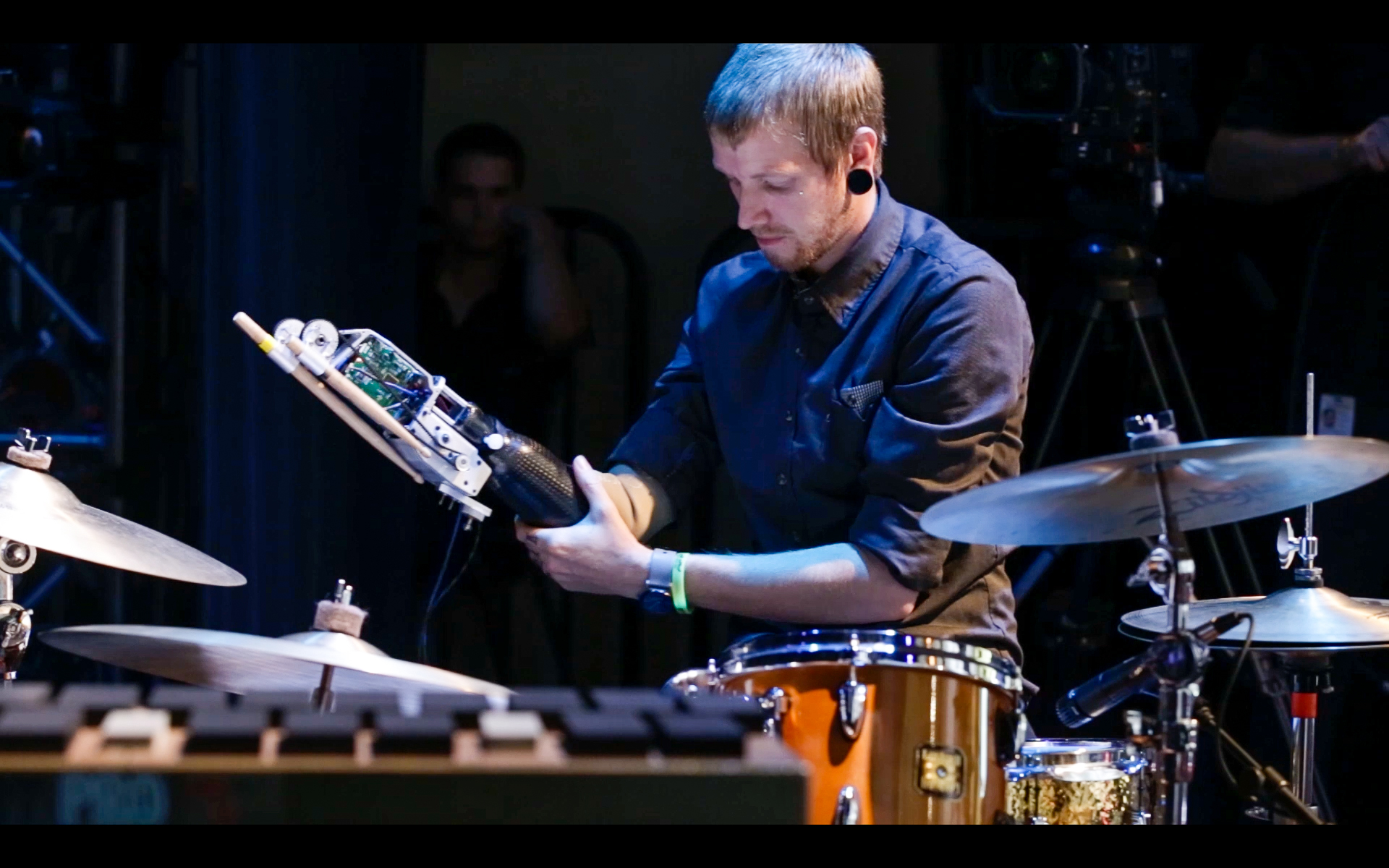 Jason Barnes performing behind a drum kit with his robotic prosthetic arm